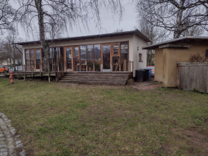 Pavillon mit bodentiefen Fenstern und Treppe zur Rasenfläche
